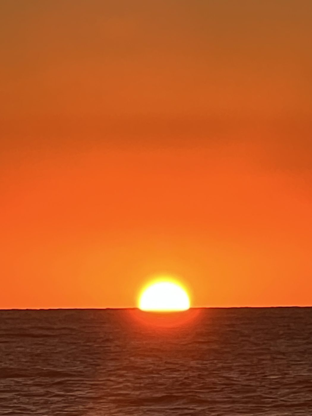 Sun setting over open water